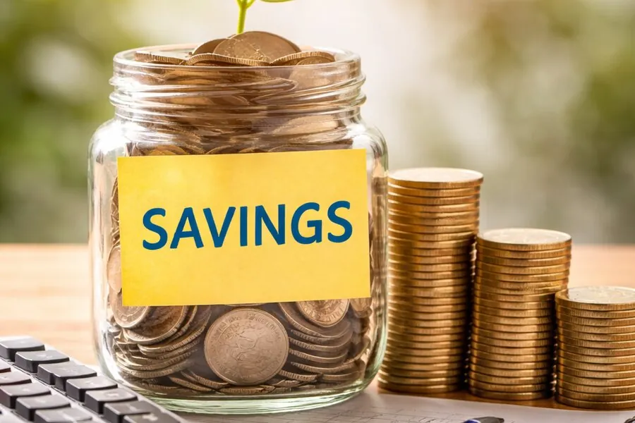Savings jar with coins and a growing plant symbolising a savings plan